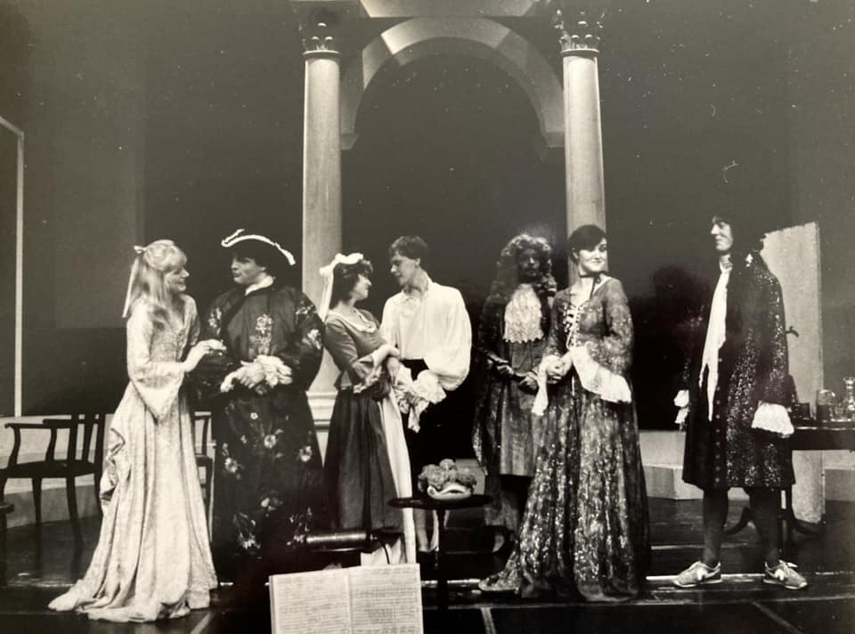 The cast, with the conductor's score visible